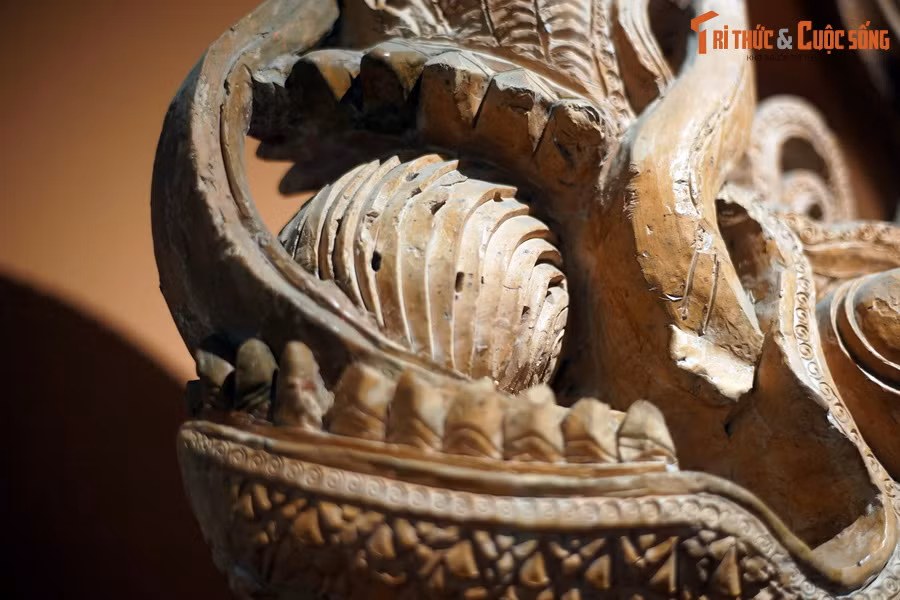 Đầu rồng có má phình rộng, miệng mở to, ngậm ngọc báu, răng được thể hiện rõ ràng.