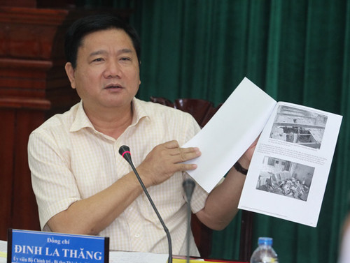 Bí thư Thành uỷ TP HCM Đinh La Thăng cầm những tấm ảnh về chung cư “ma” 727 giơ cao trước hội trường. Ảnh PLO