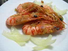 Bóc vỏ tỏi sau đó đập dập rồi cho 1 nửa chỗ tỏi vào chảo phi vàng thơm, sau đó cho tôm vào đảo đều tay tới khi tôm chuyển màu đỏ au thì vớt ra đĩa .