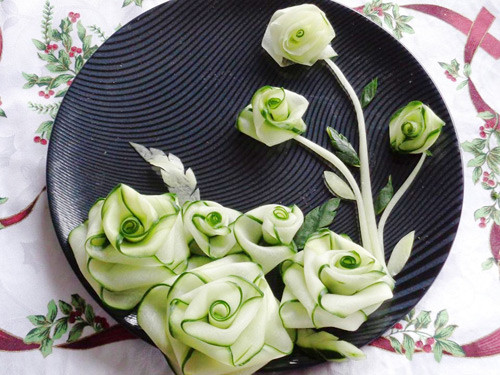  Hoa trang trí món ăn từ trái cây đầu tiên sẽ khiến bạn bất ngờ là bông hồng cánh viền xanh hút mắt tỉa từ quả dưa chuột.