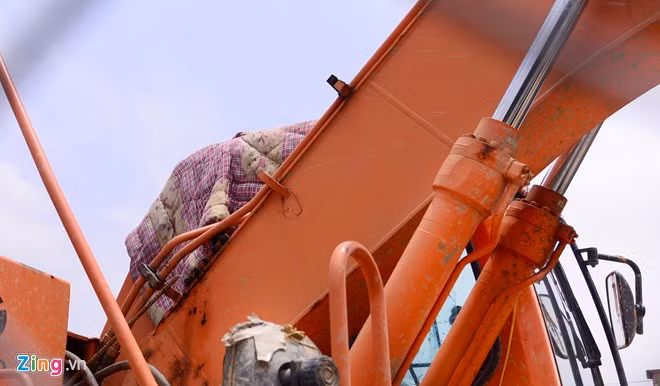 Một số cần cẩu, máy xúc được che bạt, chăn màn để tránh nắng nóng.