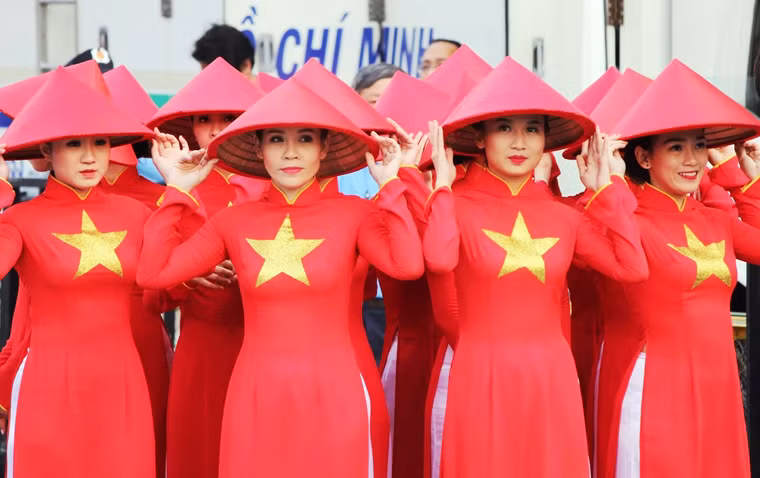 Những cô gái Sài Gòn đẹp rạng rỡ trong chiếc áo dài cờ đỏ sao vàng và chiếc nón lá truyền thống. Du khách quốc tế không ngớt trầm trồ, ấn tượng khi được tham gia lễ hội áo dài lần thứ 4 ở TP HCM.