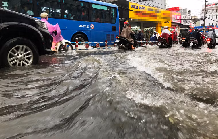 Nước mưa cuồn cuộn như những con sóng dữ trên đường phố Sài Gòn trong cơn mưa chiều 24/5.