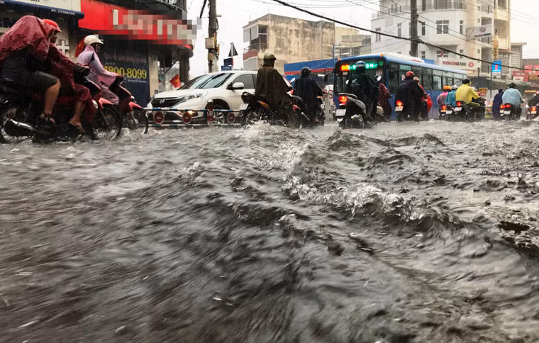 Trên địa bàn quận Thủ Đức, cả tuyến đường Võ Văn Ngân (từ trường Đại học Sư phạm Kỹ thuật đến vòng xoay ngã 5 chợ Thủ Đức) dài hơn 2km, nước mưa lênh láng, như con sông lớn khiến xe cộ bì bõm lội nước để tìm đường về nhà.