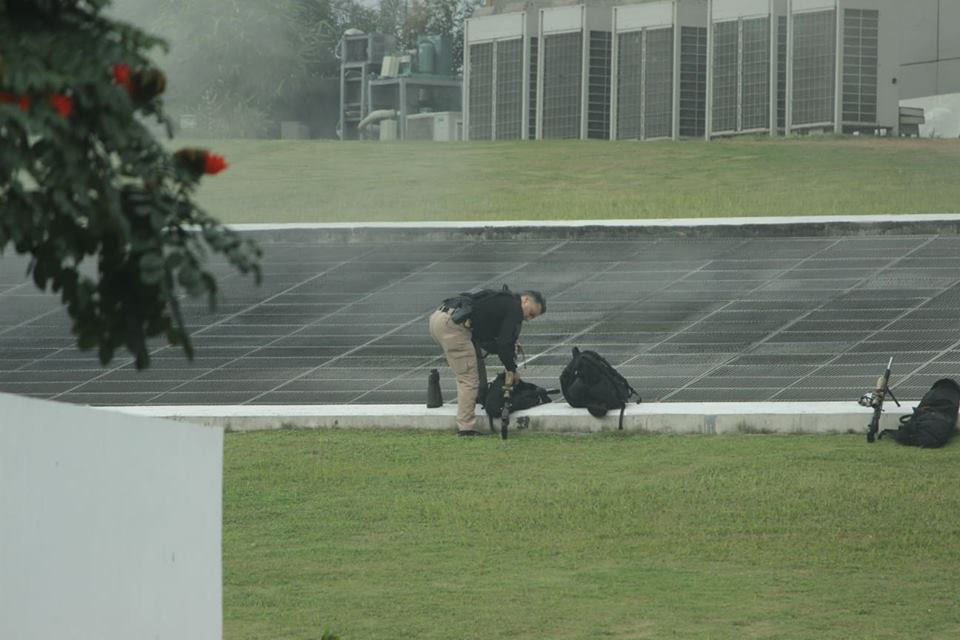 Một mật vụ lấy súng ra từ balo.