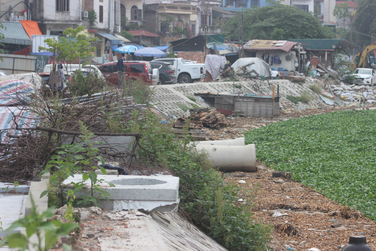 Lối vào dọc ngõ Văn Chương, người dân buôn bán tấp nập. Sạp hàng, xe đẩy được mở dọc bên đường ngay sát rào chắn khu vực cải tạo hồ. Nhiều điểm được tận dụng làm bãi tập kết xe rác, còn một góc khác được trưng dụng thành bãi để xe ôtô.