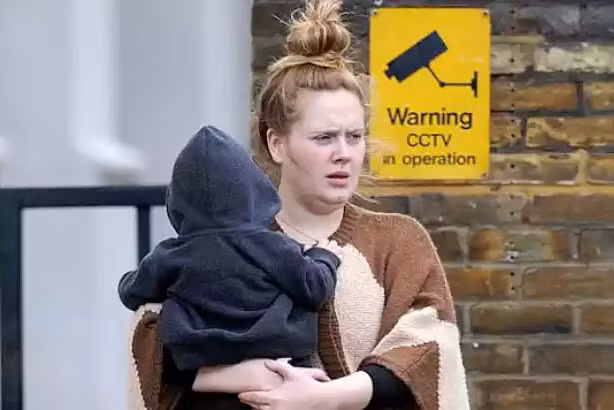 Mái tóc búi củ hành, khuôn mặt không chút son phấn, Adele bế con trai trên tay như bao bà mẹ bỉm sữa khác chứ không hề thấy hình ảnh một ngôi sao rực rỡ.