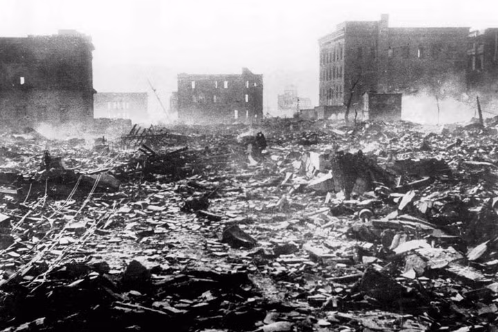 Khói vương lại trên thành phố Hiroshima hoang tàn vào ngày 7/8/1945, một ngày sau vụ nổ bom nguyên tử.