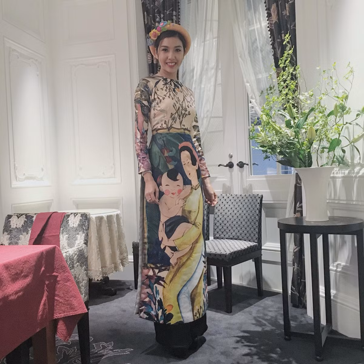 Tà áo dài thướt tha cùng hình ảnh người mẹ bế con trên tay càng làm toát lên vẻ đẹp rạng ngời của Á hậu Thúy Vân.