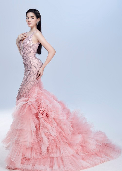 Phom dáng đầm đuôi cá cổ điển được đính kết hơn 1000 viên đá sapphire giúp Đỗ Thị Hà tôn lên đường cong hoàn hảo và nổi bật giữa đám đông. Phần đuôi váy được biến tấu lạ mắt bằng việc xếp ly lưới chuyển màu thủ công càng mô tả rõ nét hơn vẻ đẹp huyền ảo của những cánh ruộng bậc thang trong ánh nắng.