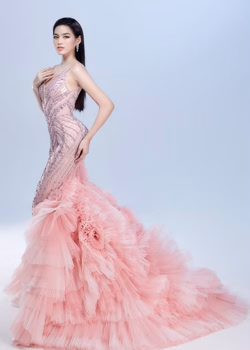 Phom dáng đầm đuôi cá cổ điển được đính kết hơn 1000 viên đá sapphire giúp Đỗ Thị Hà tôn lên đường cong hoàn hảo và nổi bật giữa đám đông. Phần đuôi váy được biến tấu lạ mắt bằng việc xếp ly lưới chuyển màu thủ công càng mô tả rõ nét hơn vẻ đẹp huyền ảo của những cánh ruộng bậc thang trong ánh nắng.
