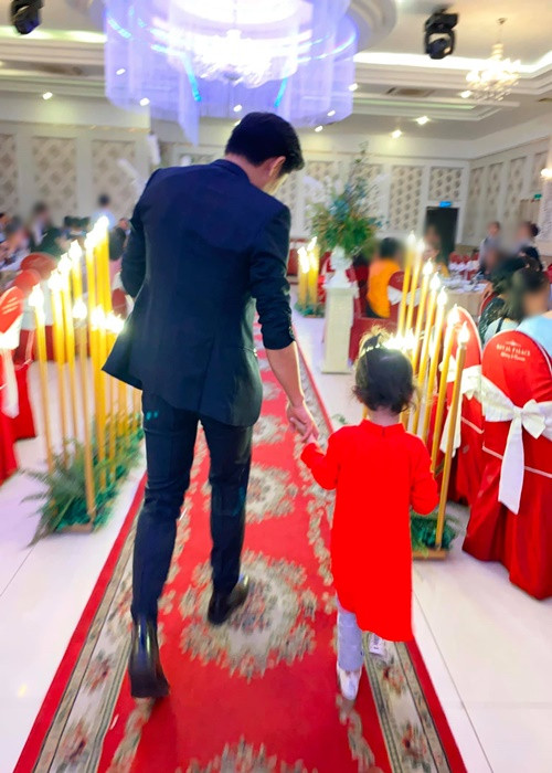 Quý Bình nắm tay con trai của Ngọc Tiền tại một bữa tiệc.