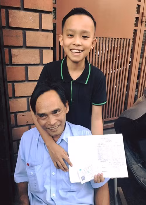 Hồ Văn Cường thi thoảng mới đăng tải hình ảnh bên bố mẹ. Trong ảnh, nam ca sĩ khoe với bố sổ liên lạc. Ảnh: FB Hồ Văn Cường