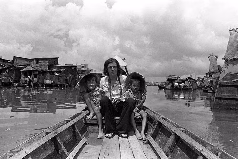 Người phóng viên và hai chú bé trên con thuyền.