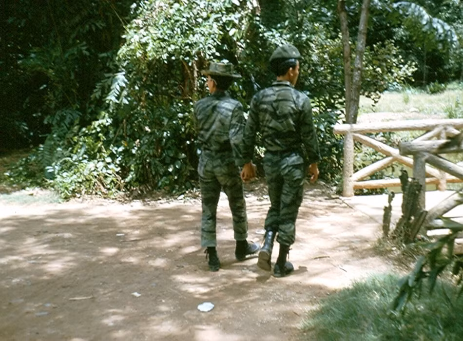 Hai anh lính cầm tay nhau đi chơi trong Thảo Cầm Viên.