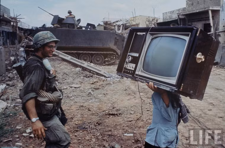 Người dân thu nhặt của cải còn sót lại trong những ngôi nhà đổ nát do chiến sự.