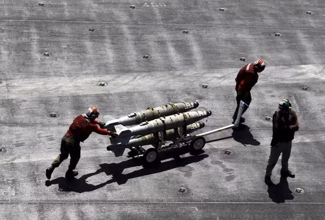 Các thành viên đội chuyên tháo gỡ vật liệu nổ (EOD) thuộc Hải quân Mỹ chuyển vũ khí trên sàn tàu sân bay hôm 18/6. Với chiều dài gần 332,8 m, boong tàu rộng hơn 1,8 hecta và là nơi cất cánh của hơn 60 máy bay chiến đấu, USS Theodore Roosevelt là một trong những tàu sân bay hiện đại và lớn nhất của Mỹ.