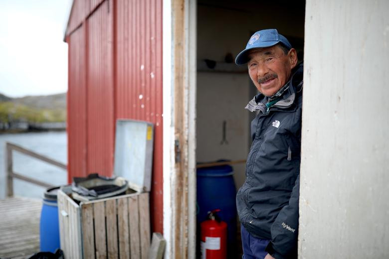 Một ngư dân đứng trước cửa ngôi nhà tại bến cảng ở Qeqertarsuatsiaat, ngày 12/9.