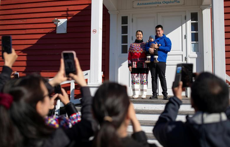 Một đôi vợ chồng trẻ cùng con chụp ảnh trong trang phục truyền thống của người Inuit sau lễ rửa tội trước Nhà thờ Nuuk ngày 5/9. 