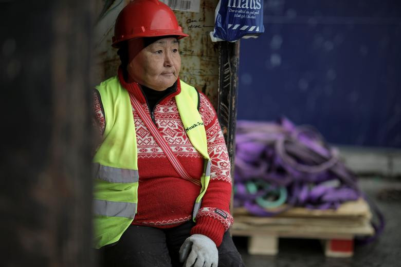 Một công nhân ngồi chờ tại bến cảng ở Nuuk hôm 7/9.