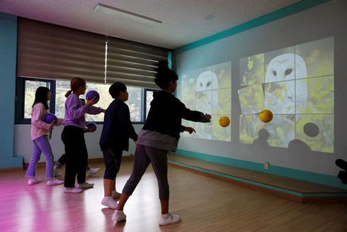 Các em nhỏ chơi game thực tế ảo nhờ công nghệ 5G hỗ trợ ở trường tiểu học Taesung. Ảnh: Reuters.
