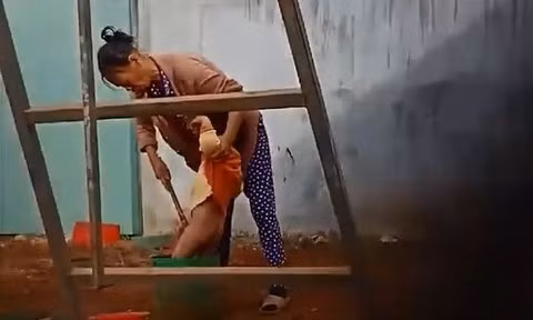 Hình ảnh bà Vấn đang dùng gậy chọc thẳng vào bộ phận sinh dục cháu. Nguồn ảnh: TPHCM