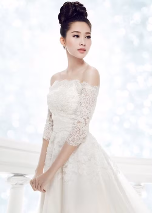 Hoa hậu Việt Nam 2012 khoe vai trần gợi cảm khi diện váy cưới trắng chất liệu ren và lựa chọn kiểu tóc búi cao gọn gàng. Ảnh: Khám phá