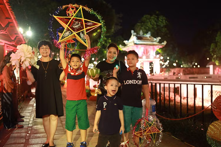 Vào các mùa Trung thu trước, các nhóc tì của BTV Quang Minh thường đi mua sắm ở phố Hàng Mã hay phá cỗ cùng hàng xóm. Ảnh: FBNV