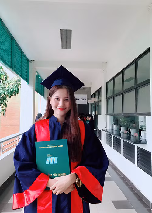 Người mẫu Hương Ly mặc áo cử nhân đi nhận bằng tốt nghiệp đại học.