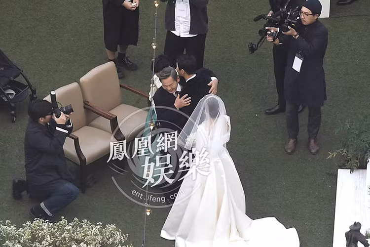 Bố mẹ của Song Joong Ki ôm chặt con trai trong đám cưới. Ảnh: Ifeng