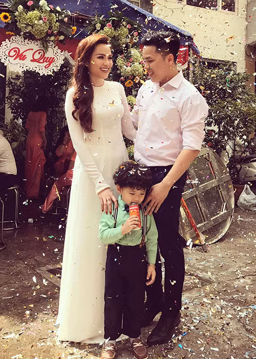 Diễm Hương diện áo dài trắng bên chồng và con tại một đám cưới của một người bạn.