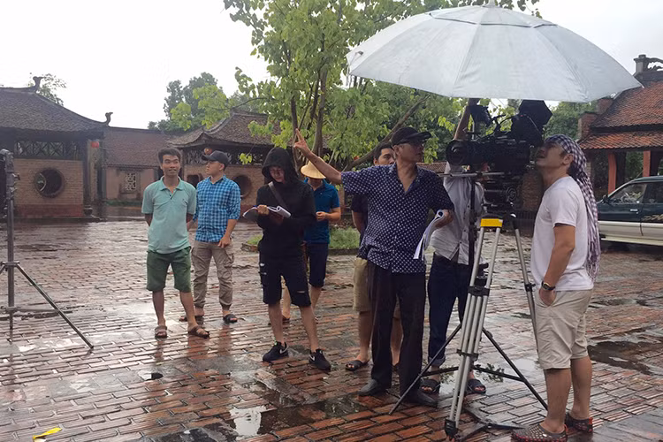 Mặc trời mưa, đạo diễn Phạm Đông Hồng và các thành viên của ê-kíp làm phim hài vẫn miệt mài quay.