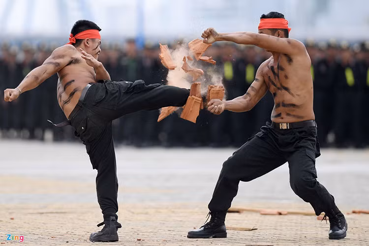 Các chiến sĩ CSCĐ biểu diễn khí công công phá mục tiêu gạch ngói bằng chân.