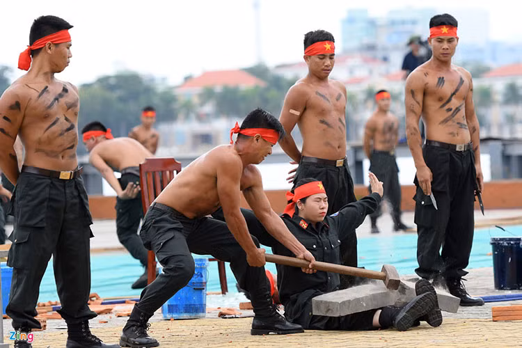 Một nữ chiến sĩ khác luyện cho đôi chân rắn khoẻ, chịu được lực đập của búa tạ công phá vỡ đá tảng trên ống đồng.