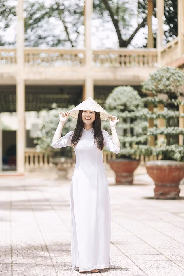 Trong tà áo dài trắng, thêm phụ kiện là chiếc nón lá, Minh Hường lại càng nổi bật hơn.