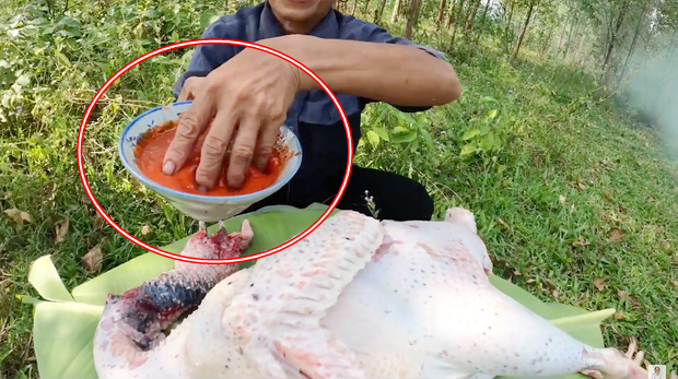 Vẫn giữ thói quen không dùng bao tay khi làm thực phẩm, lần này bà Tân vẫn tiếp tục dùng tay trần trong lúc ướp sốt siêu cay vào con gà tây.