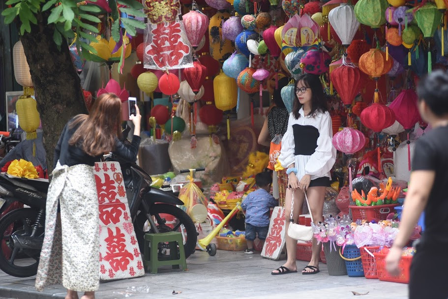 Một cô gái xinh đẹp tranh thủ đứng chụp ké trong chốc lát rồi nhường chỗ cho người dân mua bán hàng.