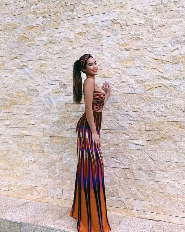 Khi bối cảnh xung quanh không có gì nổi bật hay chỉ đơn giản là một bức tường gạch không, Tiên Nguyễn lại nổi bật hẳn với set đồ sắc màu thổ cẩm. Cô không quên đính kèm tệp là tiếc turban trên đầu cho đồng bộ.