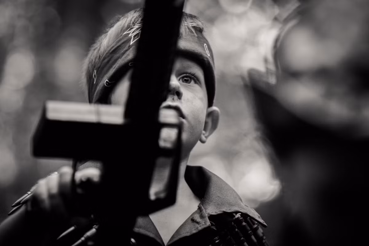 Bộ ảnh đã khá thành công trong việc làm nổi bật sự tương phản giữa nét hồn nhiên, trong sáng của các em bé với bầu không khí u ám, chết chóc của cuộc chiến. Ảnh: Hannah C - 500px.com