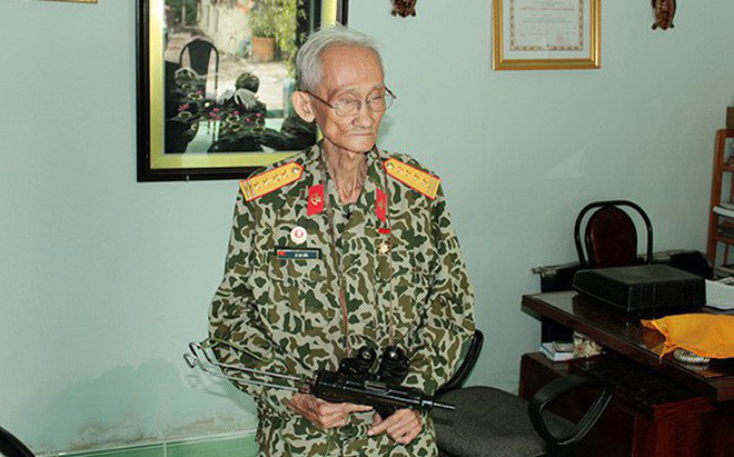 Đại tá anh hùng Đặc công Lê Bá Ước bên cạnh khẩu tiểu liên K61 huyền thoại của lực lượng đặc công rừng Sác. Nguồn ảnh: TL.