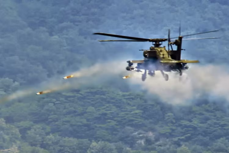 AH-64 Apache đang phóng rocket về mục tiêu.
