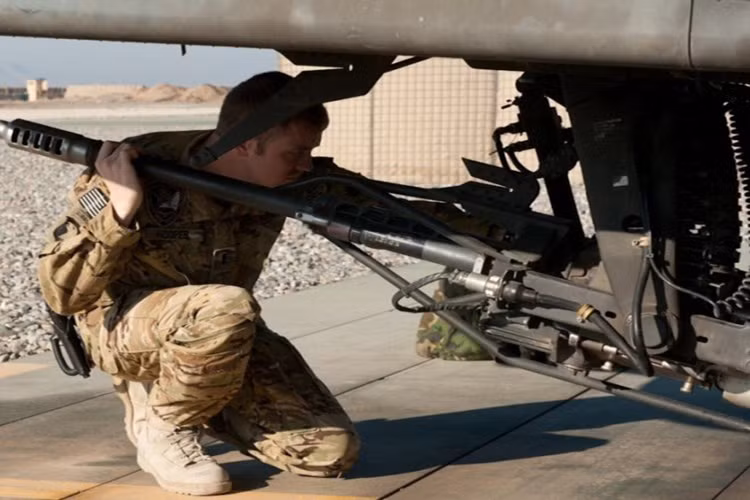 Cận cảnh kỹ thuật viên quân sự của Mỹ đang kiểm tra khẩu pháo M230 gắn trên chiếc trực thăng này.