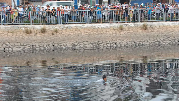 Nhiều người hiếu kỳ xem thanh niên trốn chạy dưới kênh. Ảnh: Kim Anh.