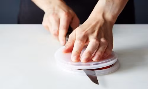 Đặt nhiều quả cà chua hoặc các loại quả có hình tròn lên mặt sau của chiếc đĩa và úp chiếc đĩa còn lại lên trên.