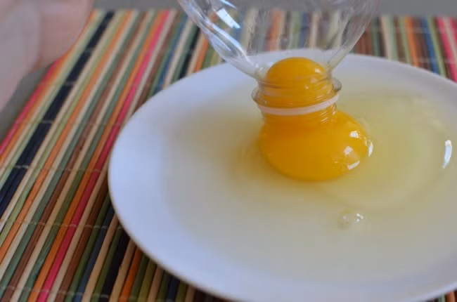 Chỉ cần một vỏ chai nhựa, bạn có thể tách lòng đỏ trứng một cách siêu nhanh. Đập trứng ra đĩa. Nhẹ nhàng bóp cho không khí ra khỏi chai nhựa.