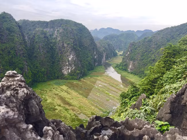 Điểm đặc biệt nhất ở Hang Múa - Ninh Bình có lẽ là núi non trùng điệp bao quanh, giữa ngọn núi xanh mướt ấy là cánh đồng lúa, dòng sông uốn lượn. Đôi khi bạn sẽ thấy cảnh thuyền rẽ sóng trên sông.