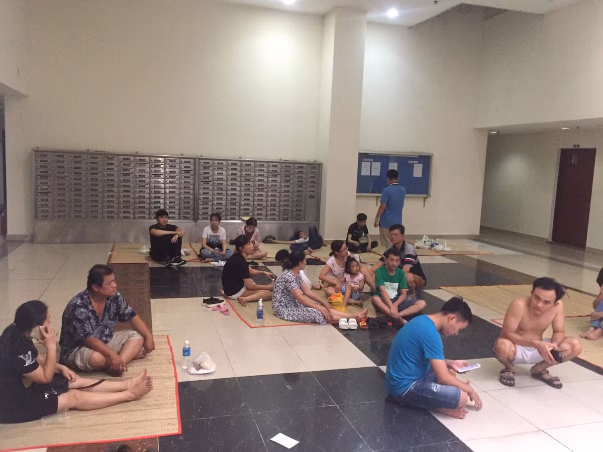 Đón nhận sự chia sẻ này, các cư dân tòa chung cư Carina Plaza ngậm ngùi: "Giờ chúng tôi chưa thể lên nhà vì cơ quan chức năng vẫn đang phong tỏa. Quần áo, tiền bạc vẫn trong nhà nên may mắn được ăn miếng canh, miếng cơm của người dân hỗ trợ thật quá cảm động". Trong ảnh, một số người dân ngồi trong phòng mà chủ đầu tư Carina Plaza tạm bố trí.