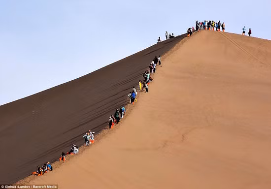 Các đoàn lữ hành dài dằng dặc nối đuôi nhau trên mảnh đất cát trắng xoá. Ảnh: Huanqiu.com.