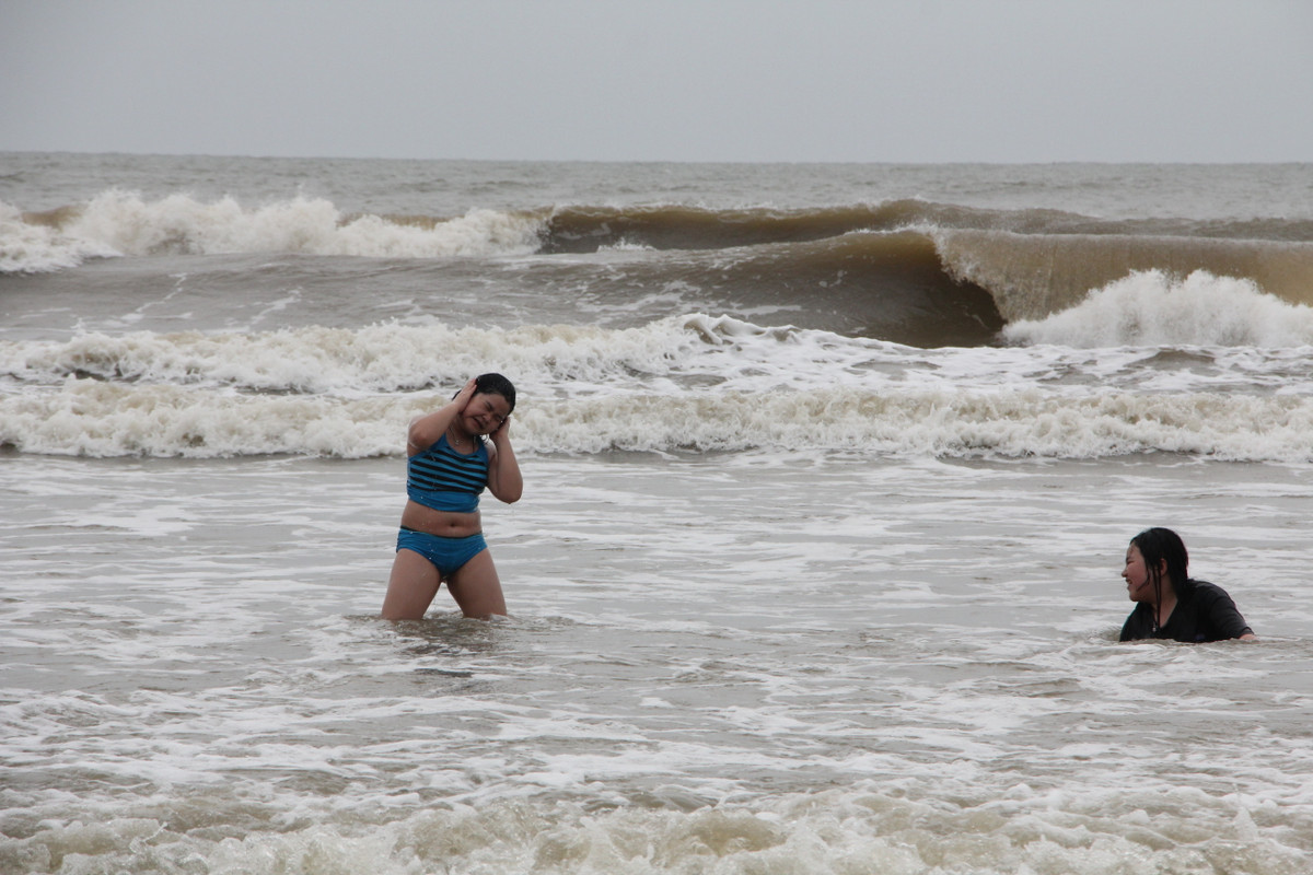 Số ít du khách vẫn xuống biển tắm.