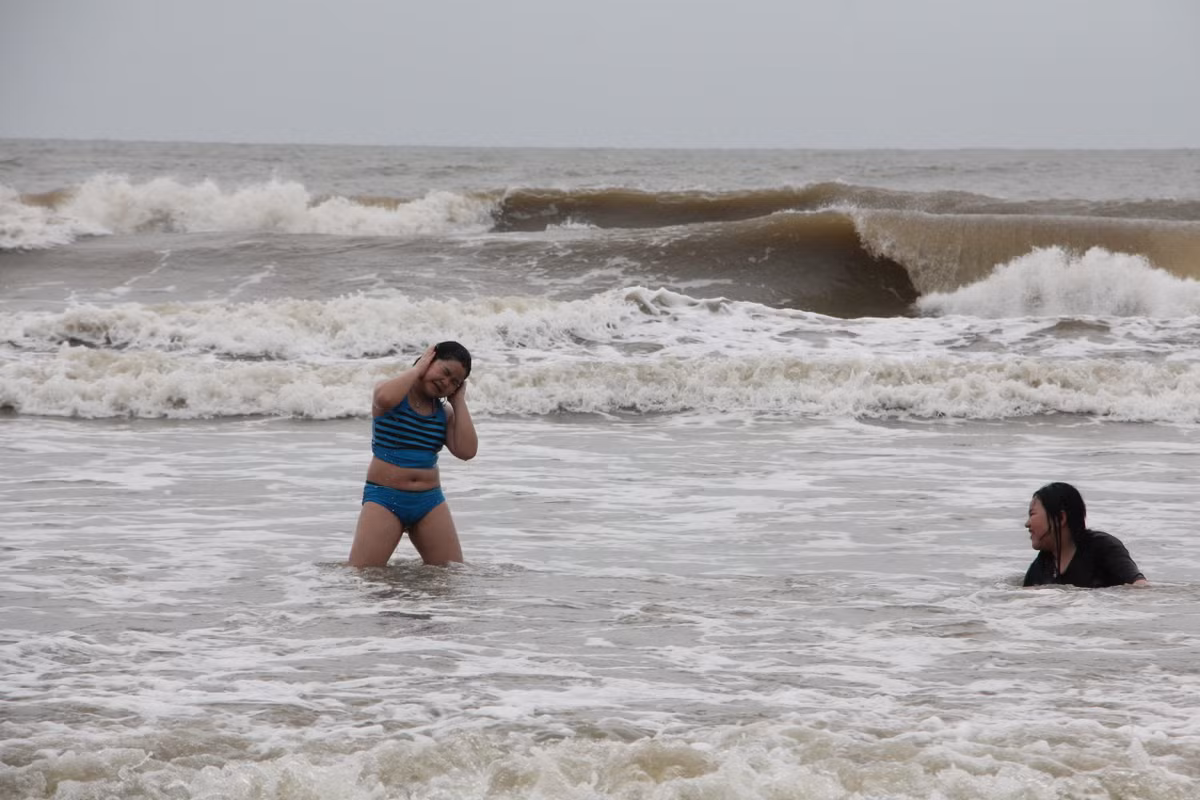 Số ít du khách vẫn xuống biển tắm.